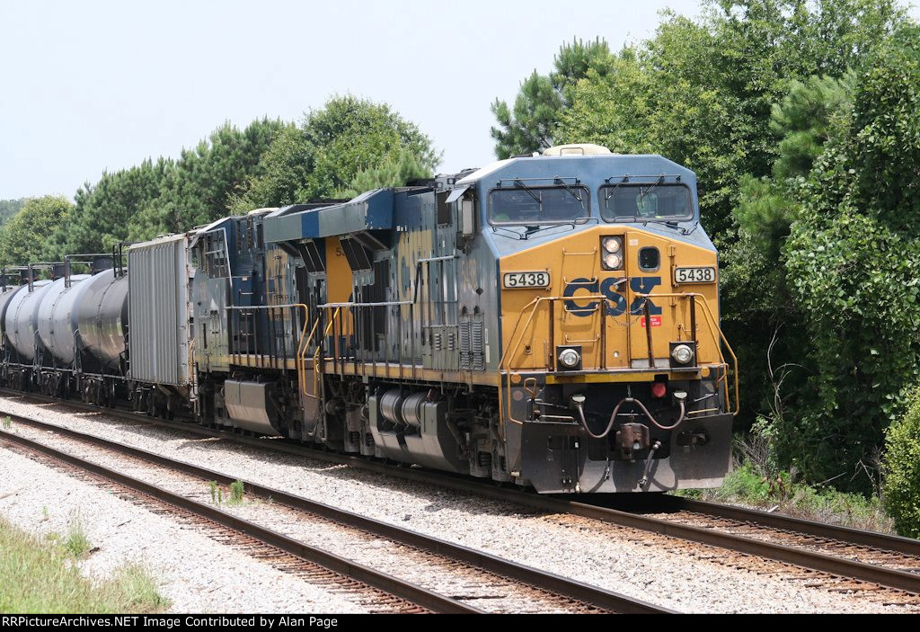 CSX 5438 and 5382 pause with a line of tank cars